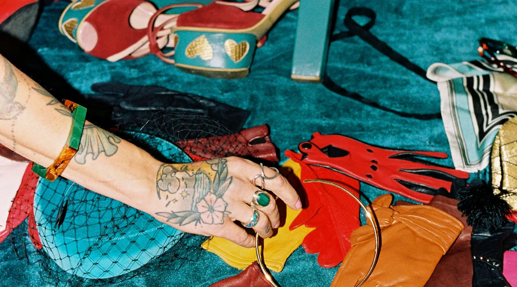 Colorful accessories including shoes, bags, and jewelry on a textured surface.