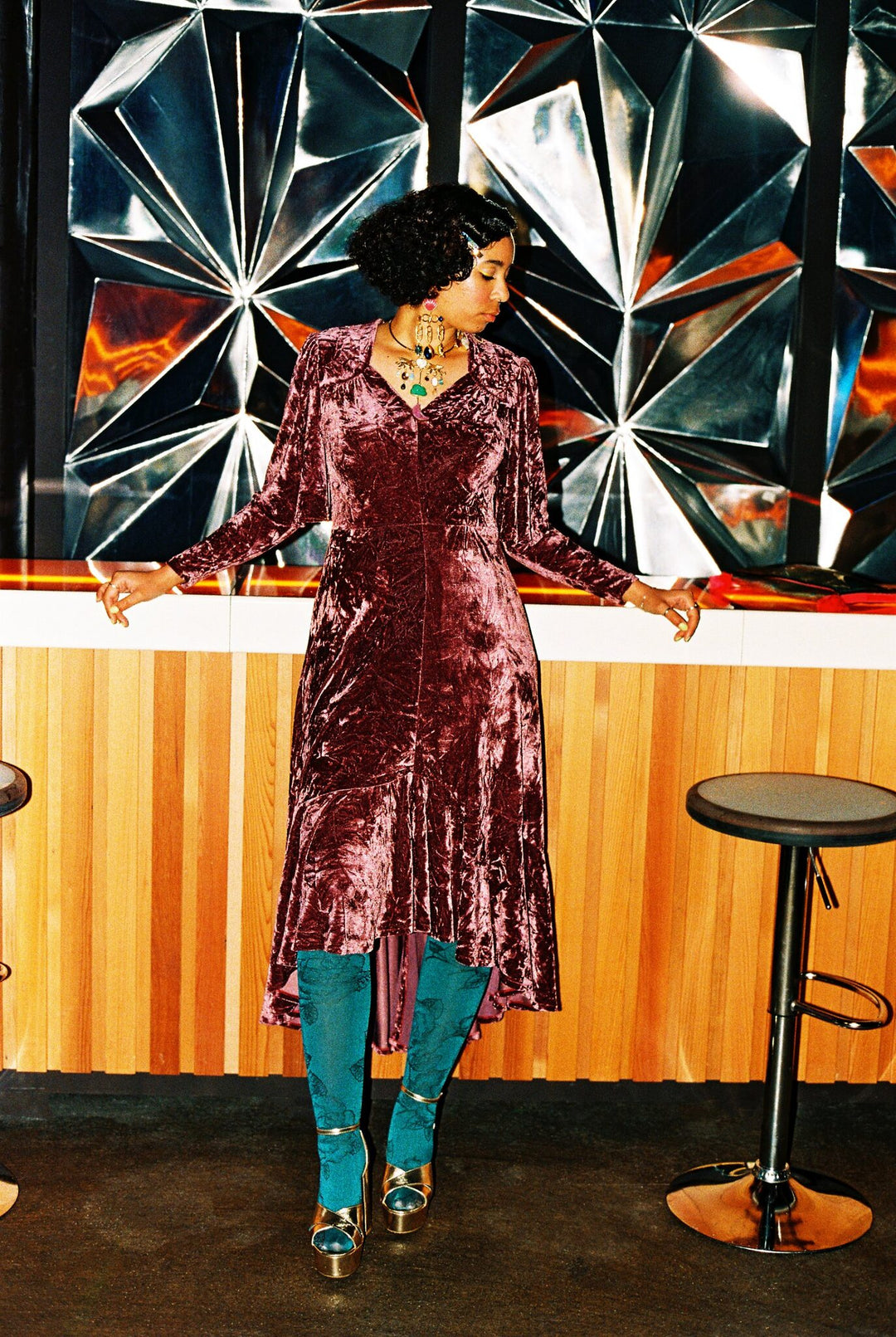 Rose crushed velvet dress worn with teal floral tights and gold platform sandals