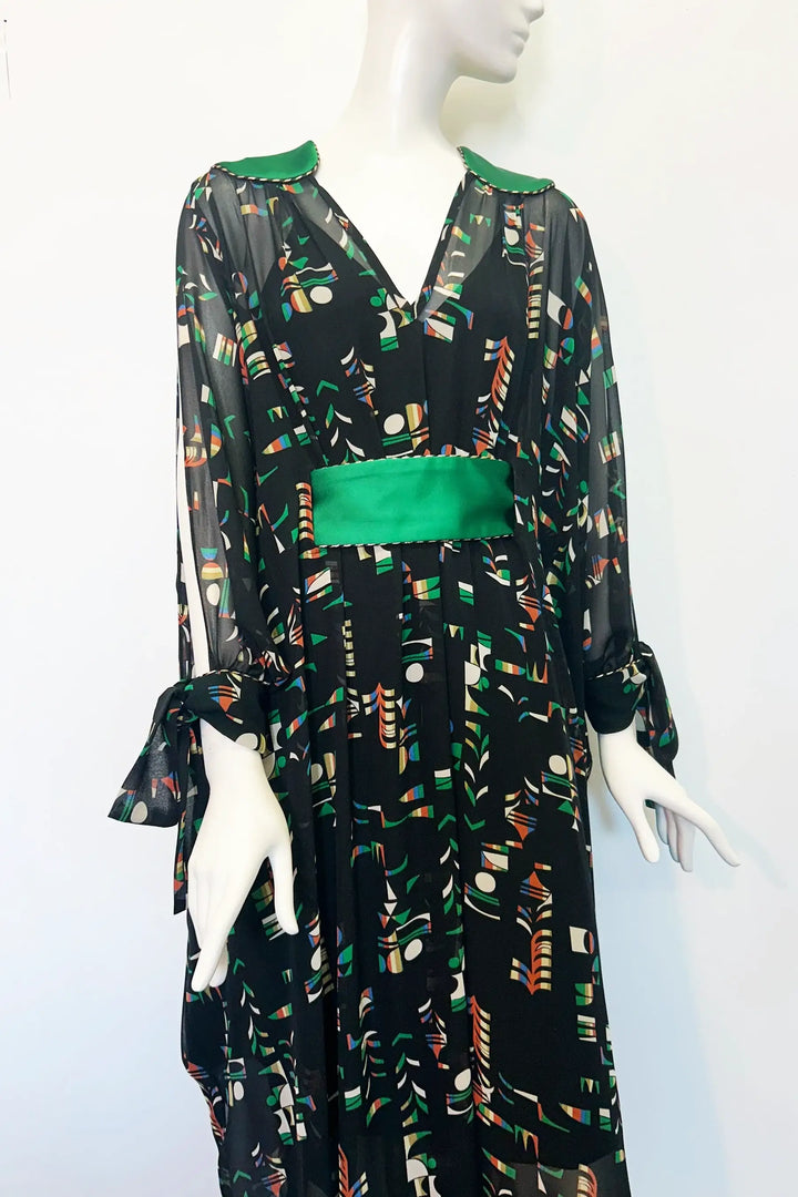 Mannequin wearing a black kaftan with colourful pattern and green accents on a white background. Handmade by Holly Campbell Studio in Edinburgh.